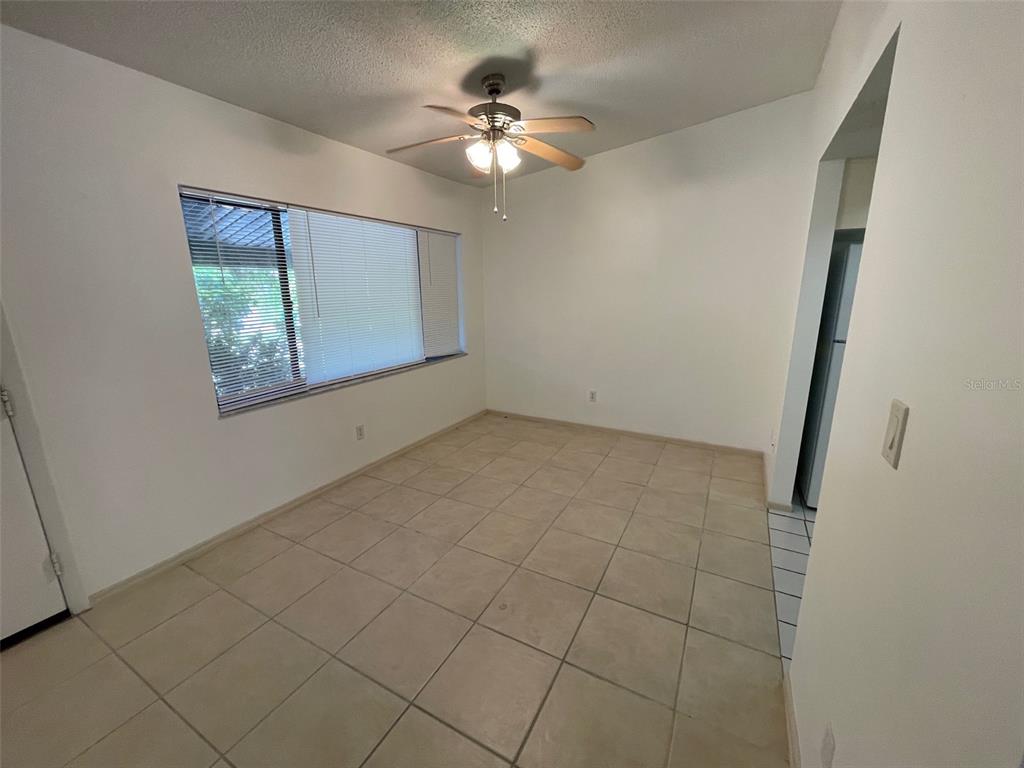 9000 Griggs Road, Unit C Englewood, FL 34224 - Photo 5 of 14 an empty room with windows and fan