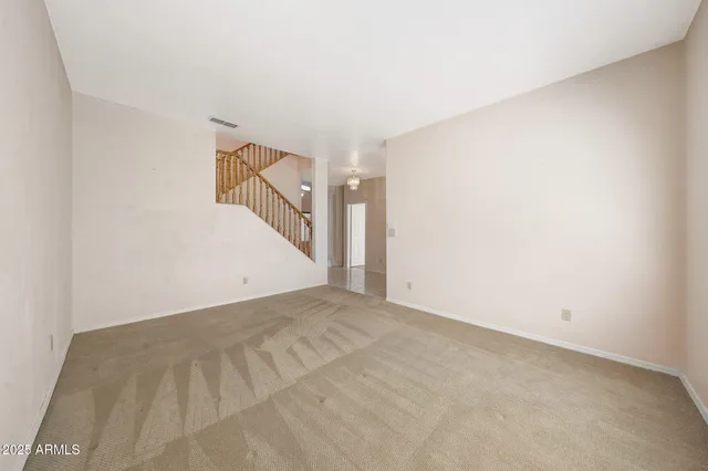 an empty room with a fan and a window