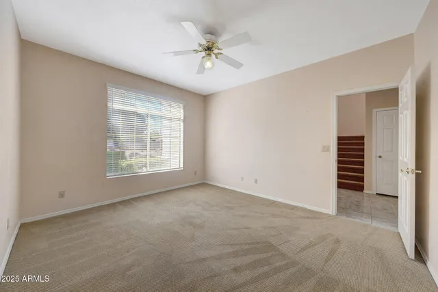 a view of an empty room with closet and a window