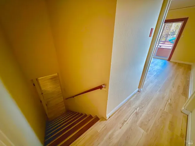 a view of a hallway with wooden floor and stairs