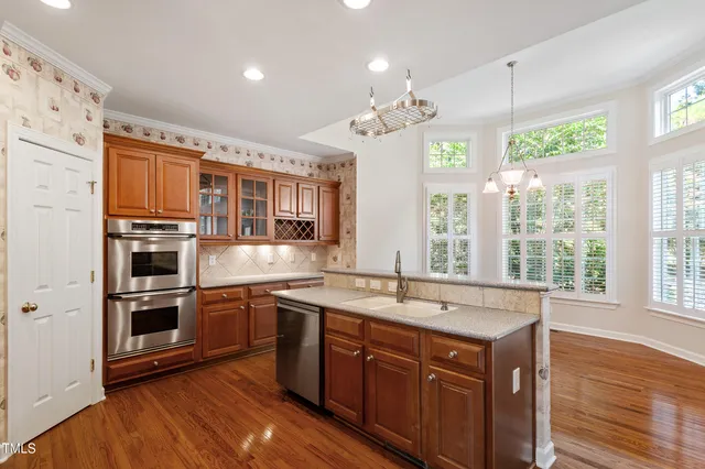a kitchen with stainless steel appliances granite countertop a sink a refrigerator and a large window