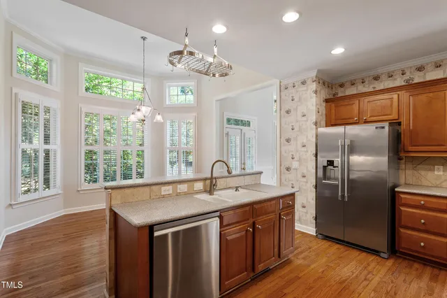 an empty room with chandelier fan and windows