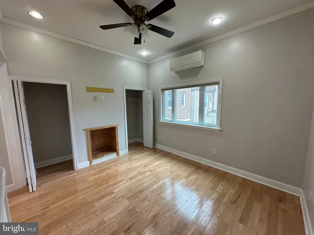 an empty room with windows and fireplace
