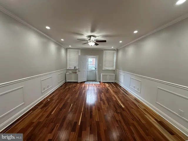 a view of empty room with wooden floor