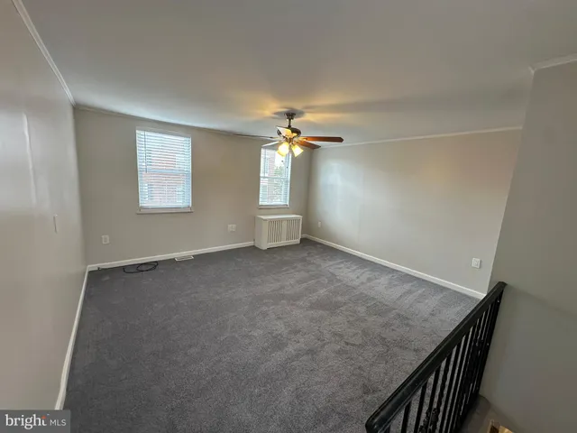 an empty room with a ceiling fan and window