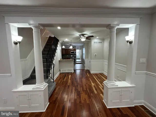 a hallway view with fireplace and wooden floor