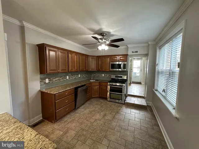 a kitchen with granite countertop a stove cabinets and refrigerator