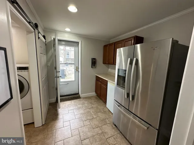 a metallic refrigerator freezer sitting inside of a kitchen