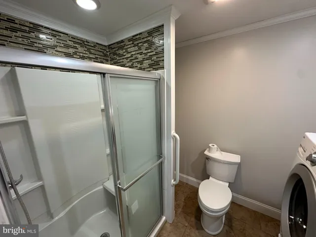 a bathroom with a toilet and a shower