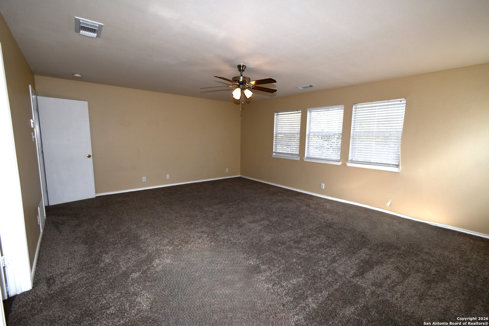 8834 Ridgefront San Antonio, TX 78250 - Photo 11 of 20 an empty room with windows and fan