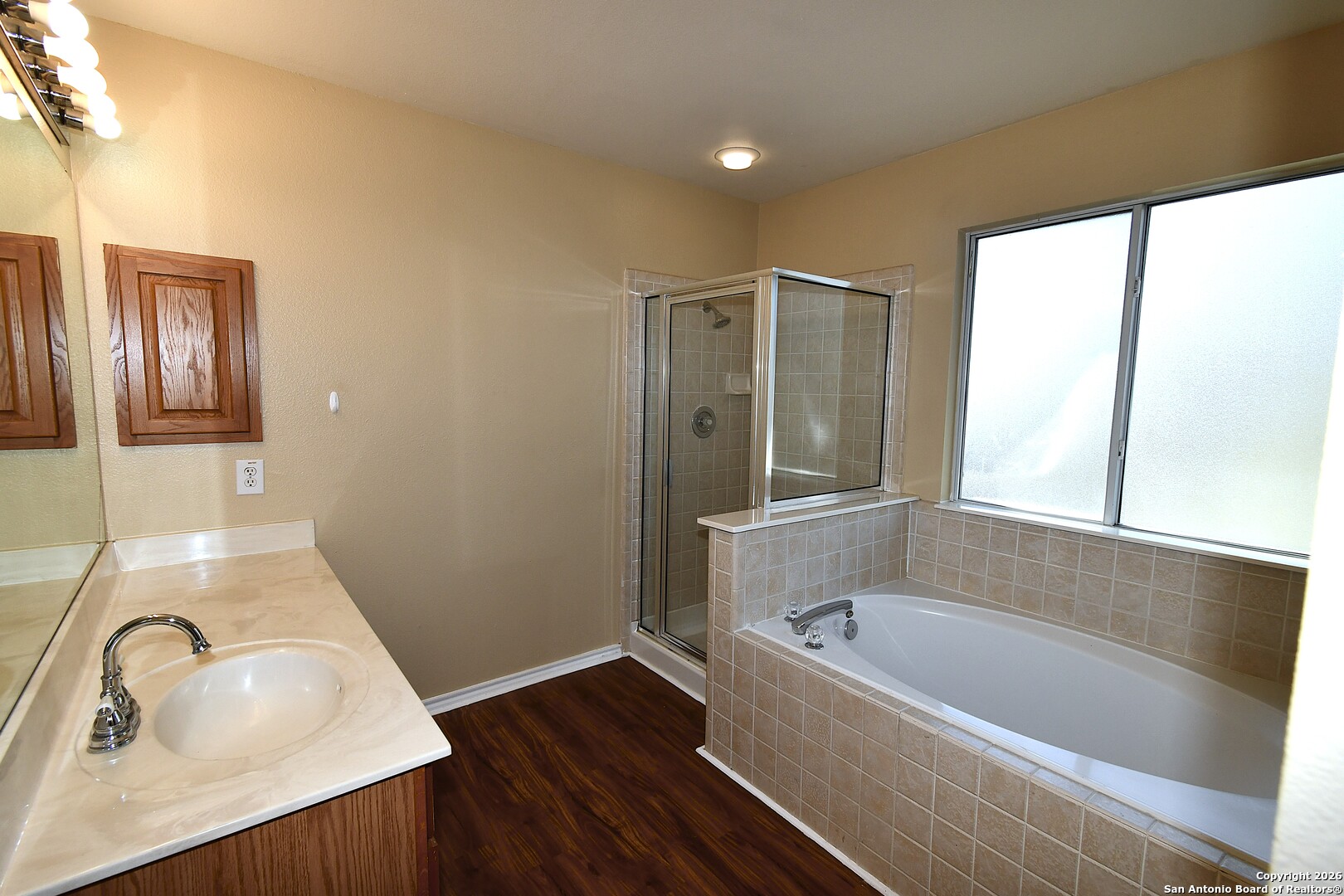 8834 Ridgefront San Antonio, TX 78250 - Photo 14 of 20 a bathroom with a tub sink and mirror