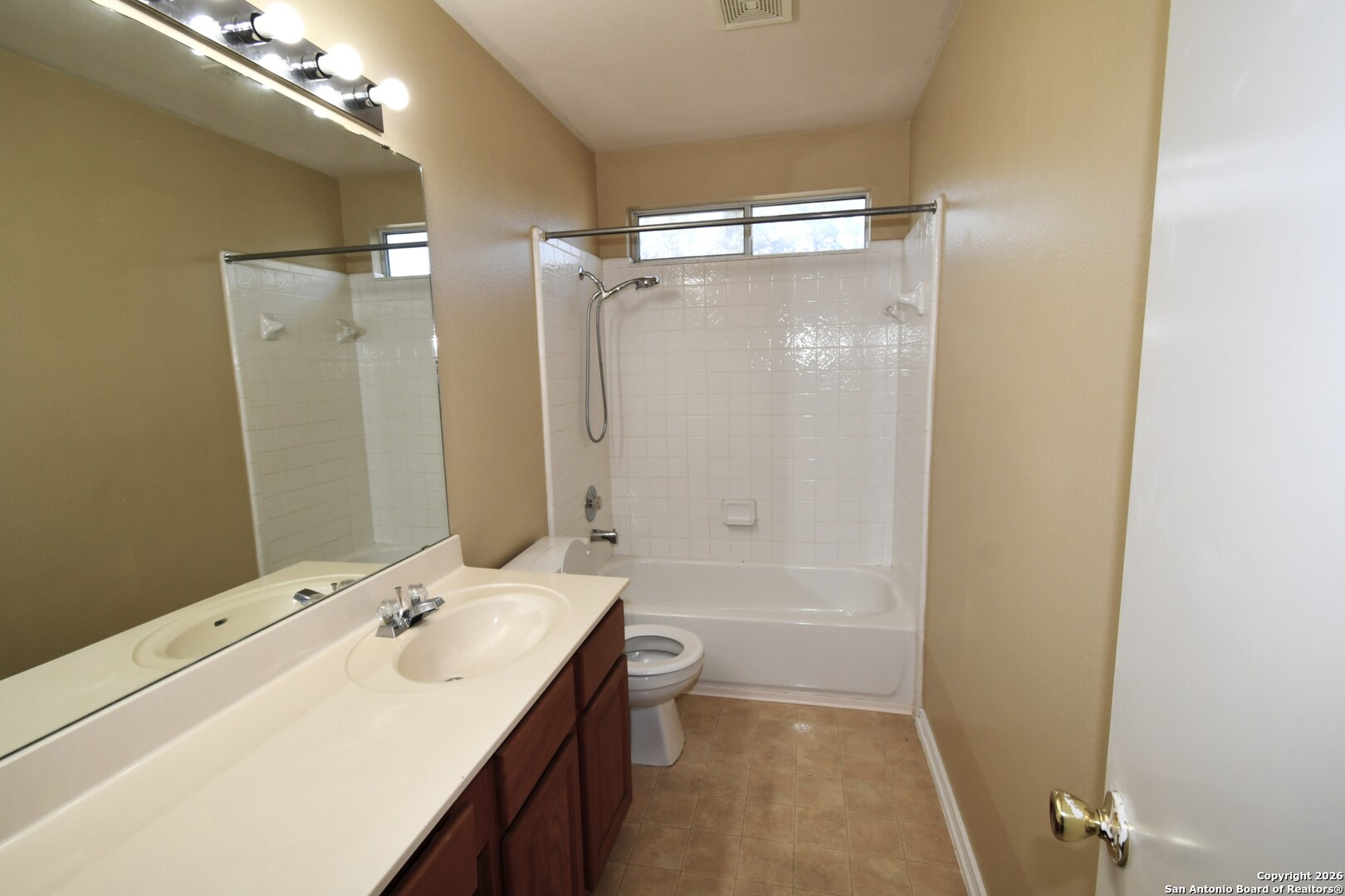 8834 Ridgefront San Antonio, TX 78250 - Photo 17 of 20 a bathroom with a double vanity sink toilet mirror and shower