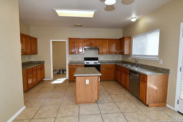 a kitchen with stainless steel appliances granite countertop a stove top oven a sink a counter top space and cabinets