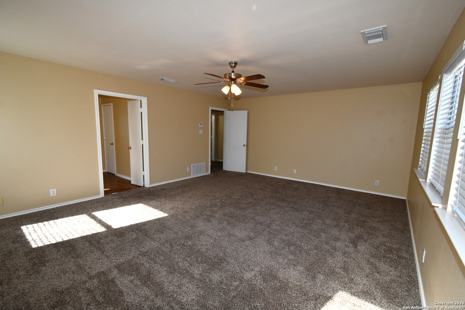 8834 Ridgefront San Antonio, TX 78250 - Photo 10 of 20 an empty room with windows and chandelier fan