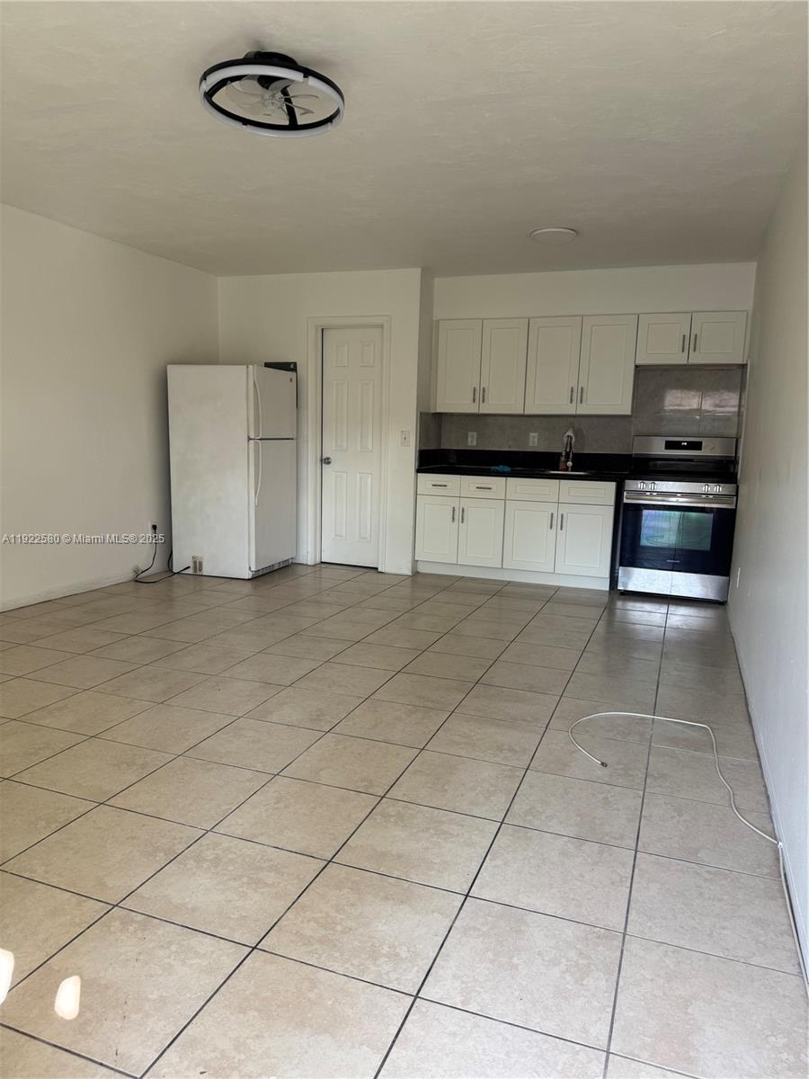 717 Northeast 1st Street, Unit 6 Hallandale Beach, FL 33009 - Photo 2 of 5 a kitchen with kitchen island cabinets and window