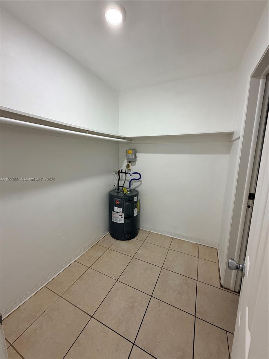 717 Northeast 1st Street, Unit 6 Hallandale Beach, FL 33009 - Photo 4 of 5 a view of water heater room with cabinet