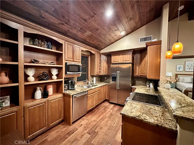 a kitchen with stainless steel appliances granite countertop a stove a sink and a refrigerator
