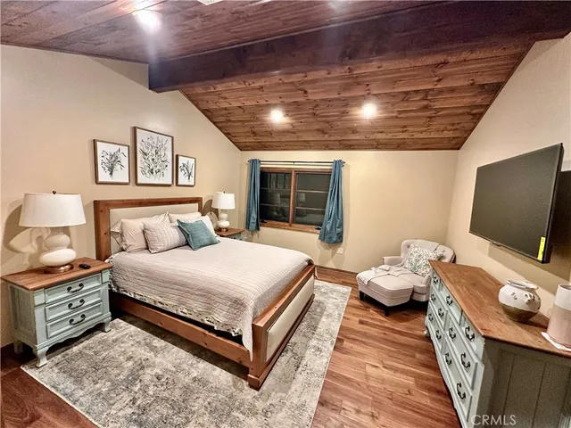 a spacious bedroom with a bed and a flat screen tv