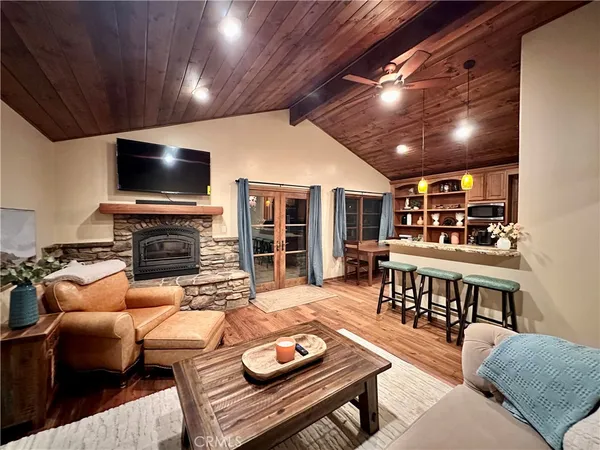 a living room with furniture a flat screen tv and kitchen view