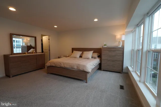 a bedroom with a bed and a large window