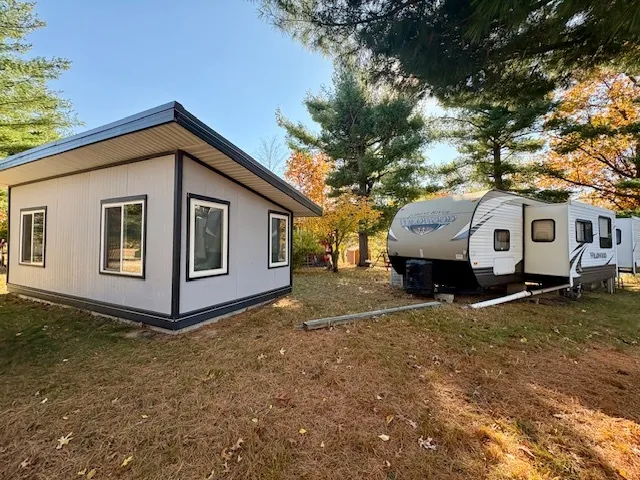a view of a white house with a large tree in front of a house