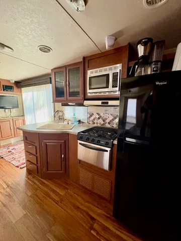 a kitchen with stainless steel appliances granite countertop a stove and a microwave