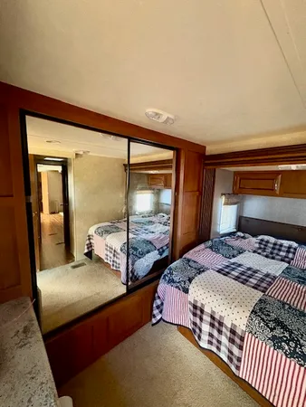 a bedroom with a large bed and two large window