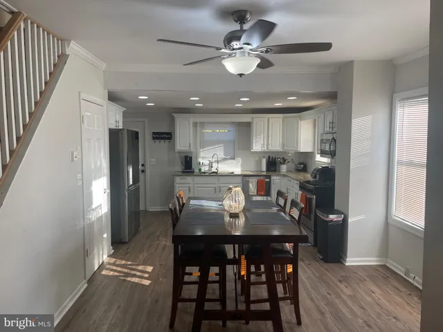 a kitchen with stainless steel appliances kitchen island granite countertop a refrigerator a stove a microwave oven with a dining table and chairs