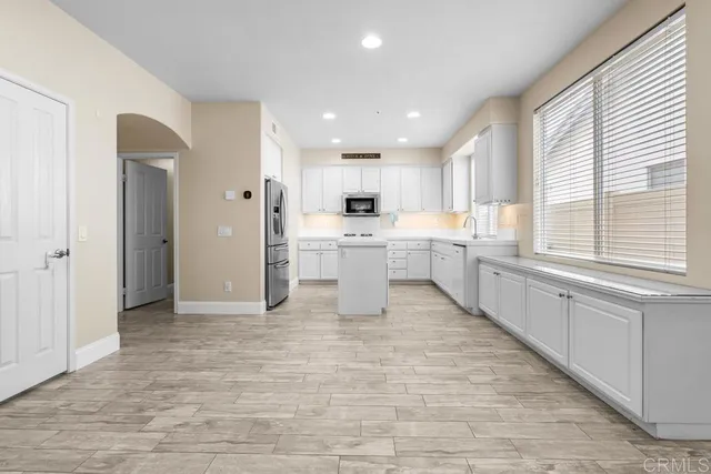 a kitchen with white cabinets and stainless steel appliances