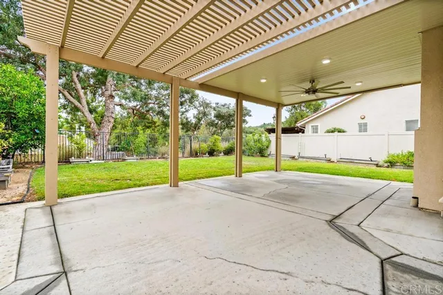 a view of a white house with a big yard and large trees