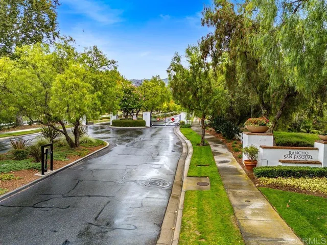 a view of a white house with a big yard and potted plants