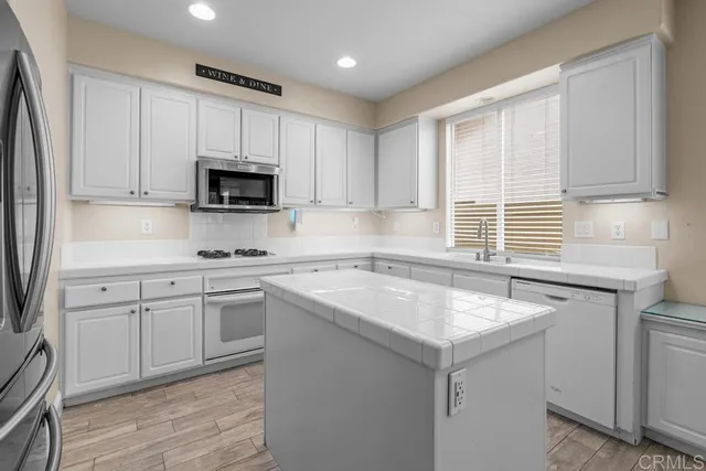 a kitchen with stainless steel appliances granite countertop a sink stove and microwave