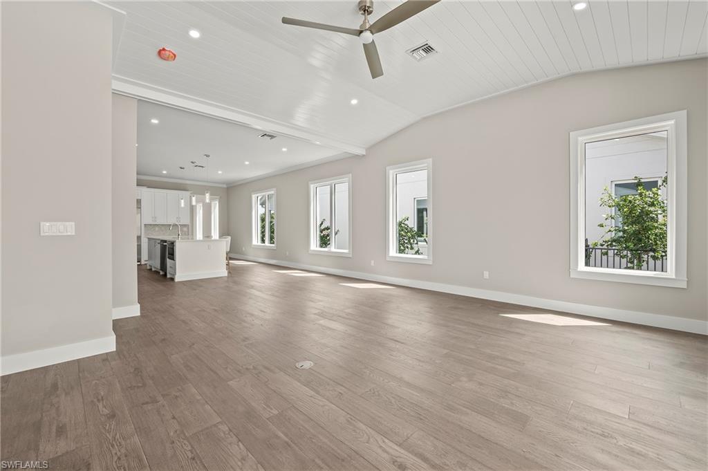 1134 Trail Terrace Drive Naples, FL 34103 - Photo 10 of 37 Unfurnished living room with lofted ceiling, light wood-type flooring, baseboards, ceiling fan, and visible vents