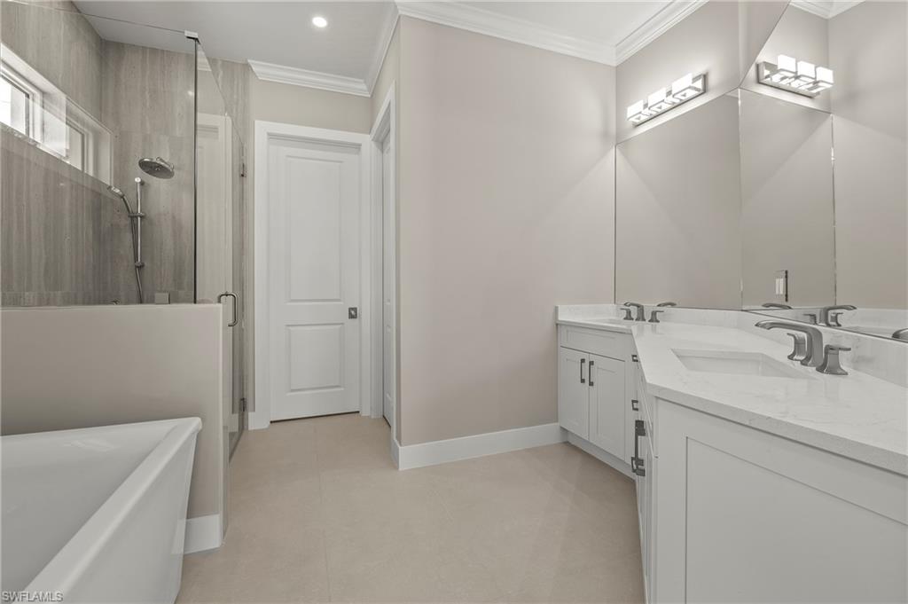 1134 Trail Terrace Drive Naples, FL 34103 - Photo 20 of 37 Full bathroom featuring a shower with shower door, double vanity, crown molding, and a freestanding bath