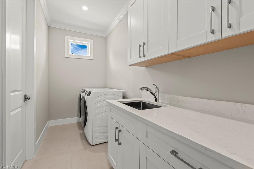 1134 Trail Terrace Drive Naples, FL 34103 - Photo 25 of 37 Laundry area with independent washer and dryer, ornamental molding, baseboards, a sink, and cabinet space