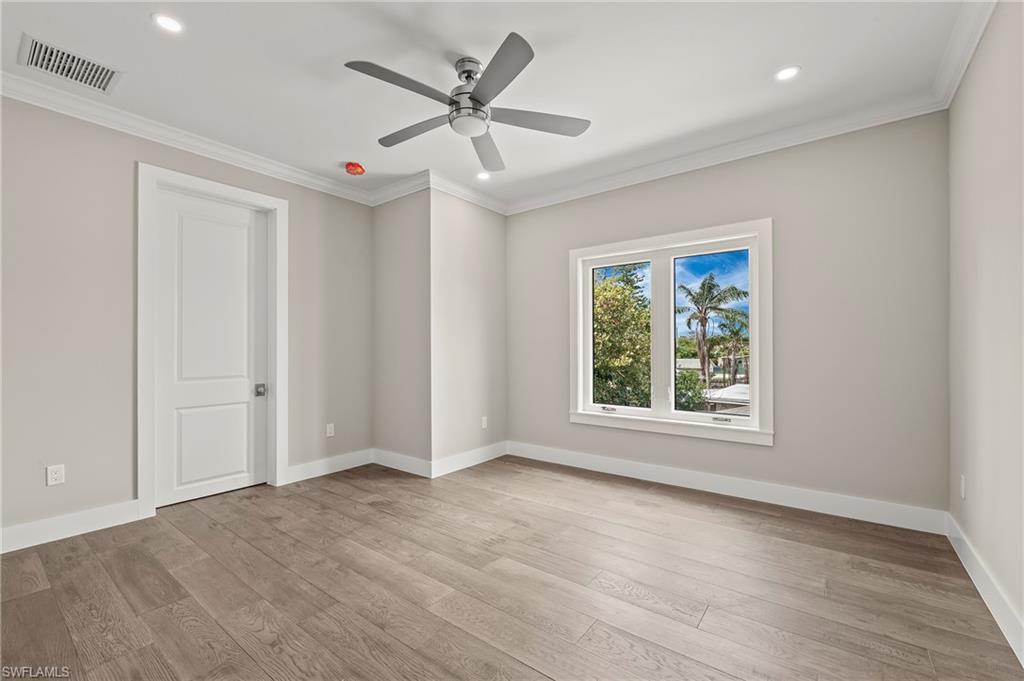 1134 Trail Terrace Drive Naples, FL 34103 - Photo 26 of 37 Spare room featuring wood finished floors, baseboards, visible vents, ceiling fan, and ornamental molding