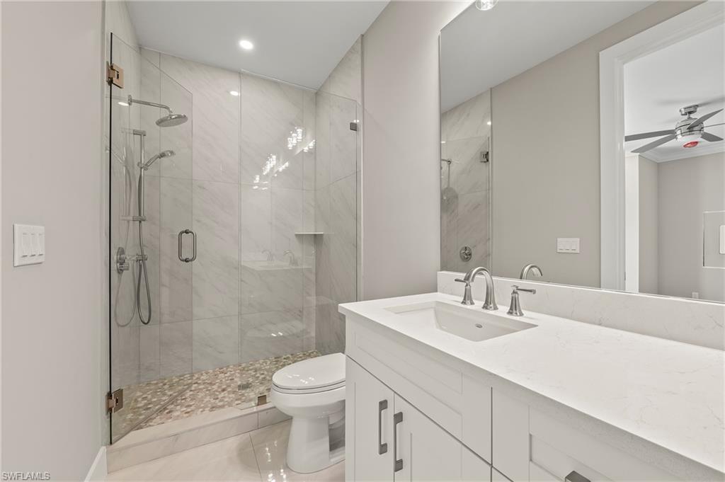 1134 Trail Terrace Drive Naples, FL 34103 - Photo 27 of 37 Bathroom featuring a stall shower, toilet, vanity, and a ceiling fan