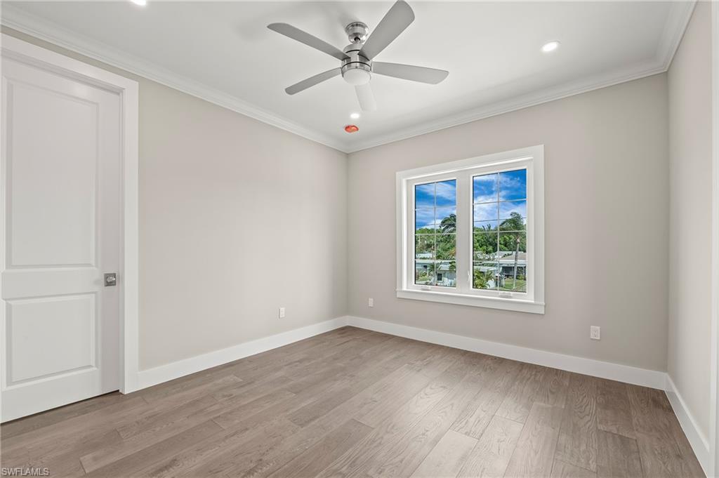 1134 Trail Terrace Drive Naples, FL 34103 - Photo 28 of 37 Unfurnished room with light wood finished floors, baseboards, ornamental molding, and a ceiling fan