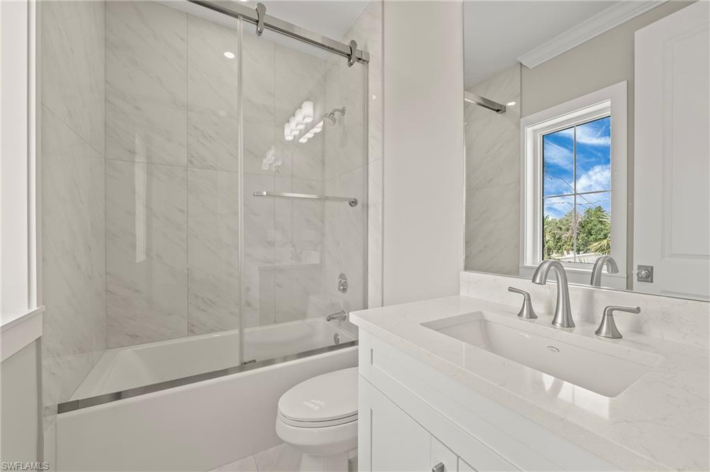 1134 Trail Terrace Drive Naples, FL 34103 - Photo 30 of 37 Full bath featuring vanity, crown molding, toilet, and bath / shower combo with glass door