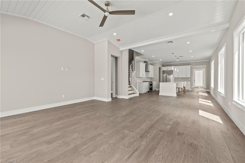 1134 Trail Terrace Drive Naples, FL 34103 - Photo 9 of 37 Unfurnished living room featuring visible vents, crown molding, baseboards, a ceiling fan, and light wood-style floors