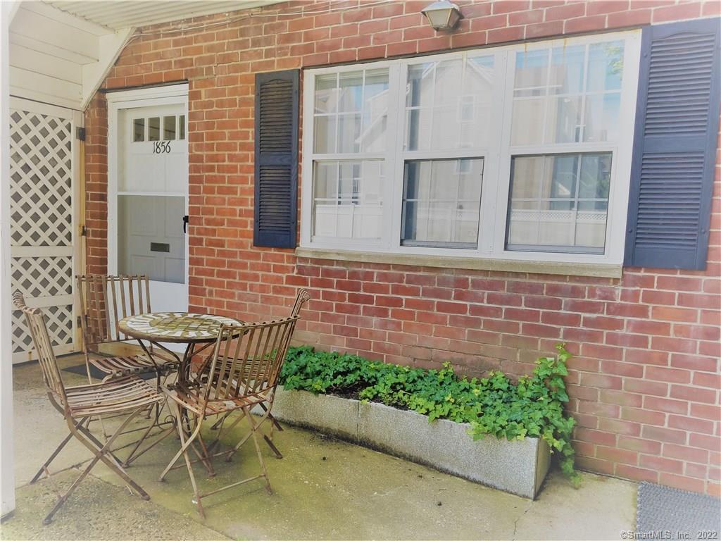 a view of a brick wall with a chair and table in the house