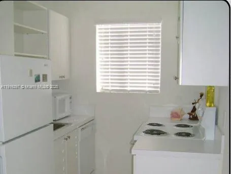 a room with a window a sink and wooden cabinets