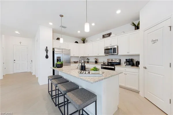 a kitchen with stainless steel appliances granite countertop a stove a sink and a microwave