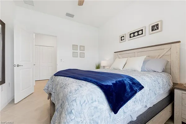 a bedroom with a large bed and a potted plant