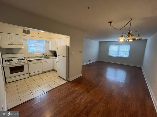 a kitchen with wooden floors and appliances