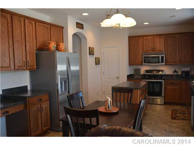 6533 Del Rio Road Charlotte, NC 28277 - Photo 10 of 15 a kitchen with stainless steel appliances granite countertop a refrigerator a stove a sink dishwasher with a dining table and chairs