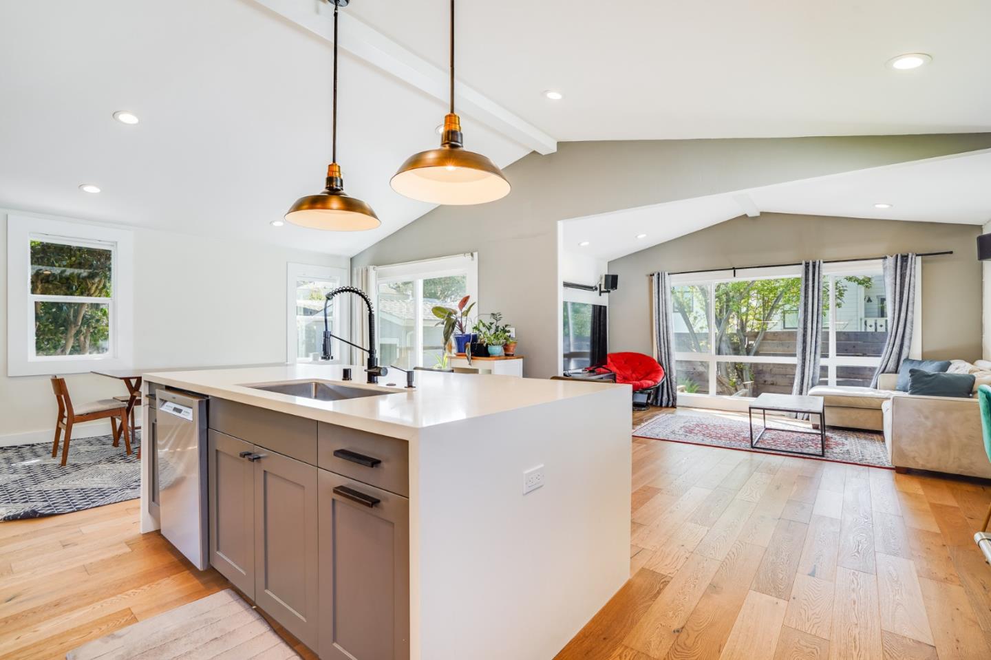 985 44th Street Oakland, CA 94608 - Photo 15 of 41 a kitchen with stainless steel appliances granite countertop a sink dishwasher and a dining table with wooden floor