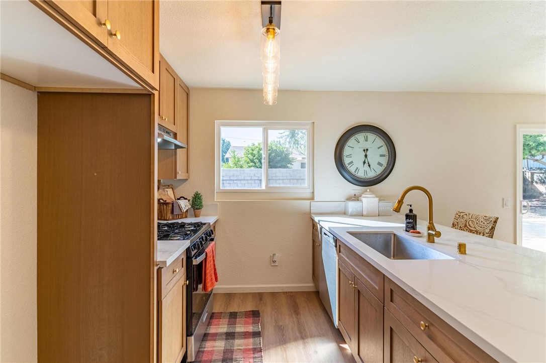 7738 Encinitas Avenue Fontana, CA 92336 - Photo 12 of 35 a kitchen with a sink a clock and cabinets