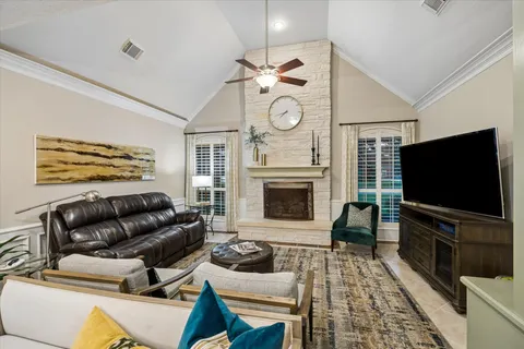 a living room with furniture a flat screen tv and a fireplace