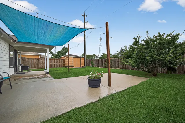 a view of a patio with a table and chairs potted plants with wooden fence
